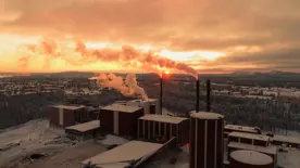 Värmeverket fotat från luften snö ligger på marken och rök kommer ur skorstenarna