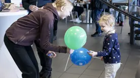 Flicka som ger ballong och godis till barn