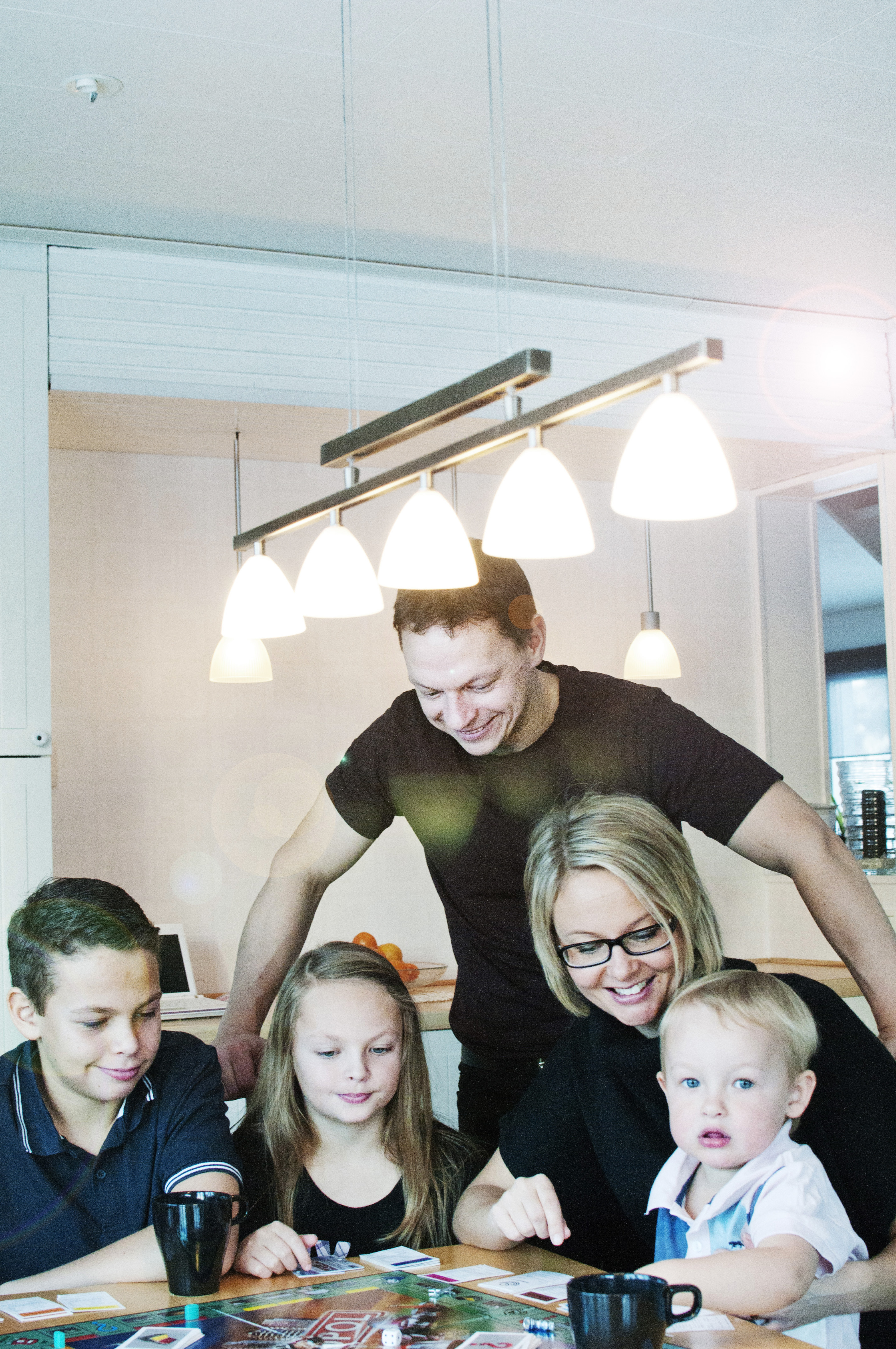 Två vuxna och fyra barn spelar spel i köksmiljö