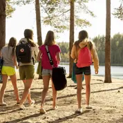 Fyra flickor går på stranden mot vattnet